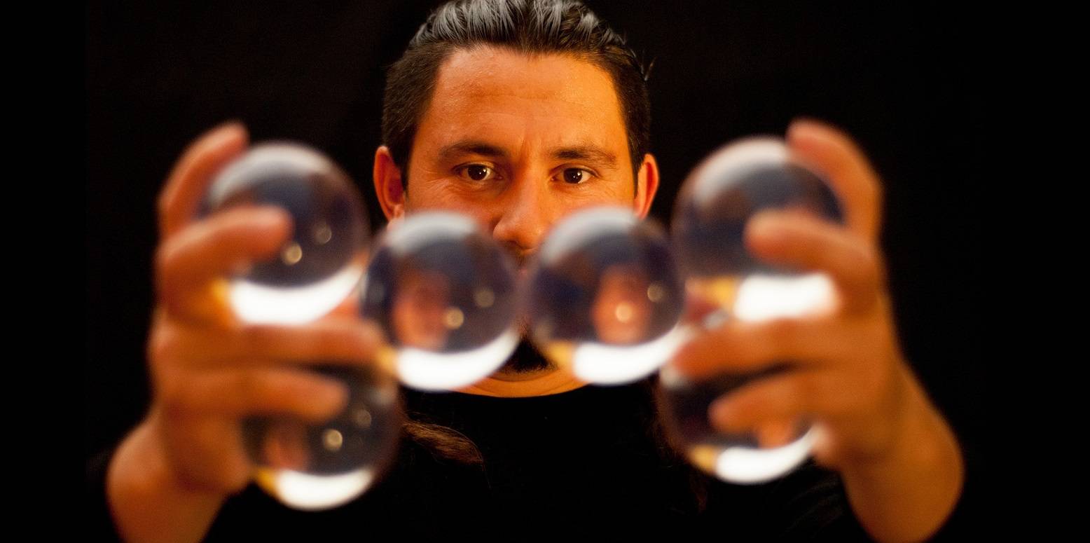 Photo d'une personne tenant six balles de jonglage dans un équilibre précaire